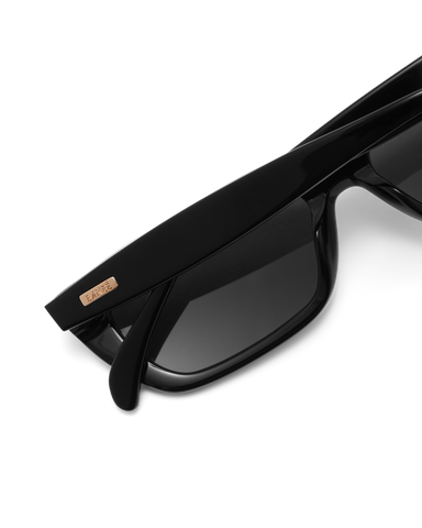 Black sunglasses with dark lenses on a white background.