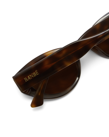 Sunglasses with tortoiseshell frame and brown lenses on a white background