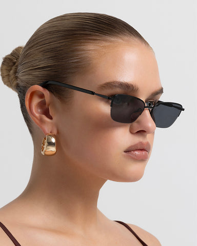 Women’s metal cat-eye sunglasses with UV protection, thin frame, dark tinted lenses, side view on model
