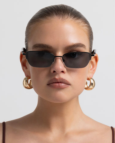Women’s metal cat-eye sunglasses with UV protection, thin frame, dark tinted lenses, front view on model