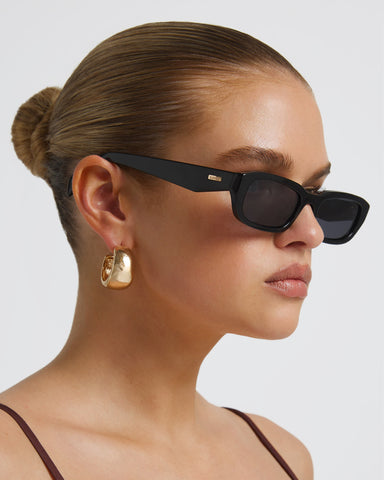 Women's sunglasses with a rectangular silhouette, chunky acetate frame, tonal tinted lenses, and wide arms for a bold, modern look with UV protection, front view.