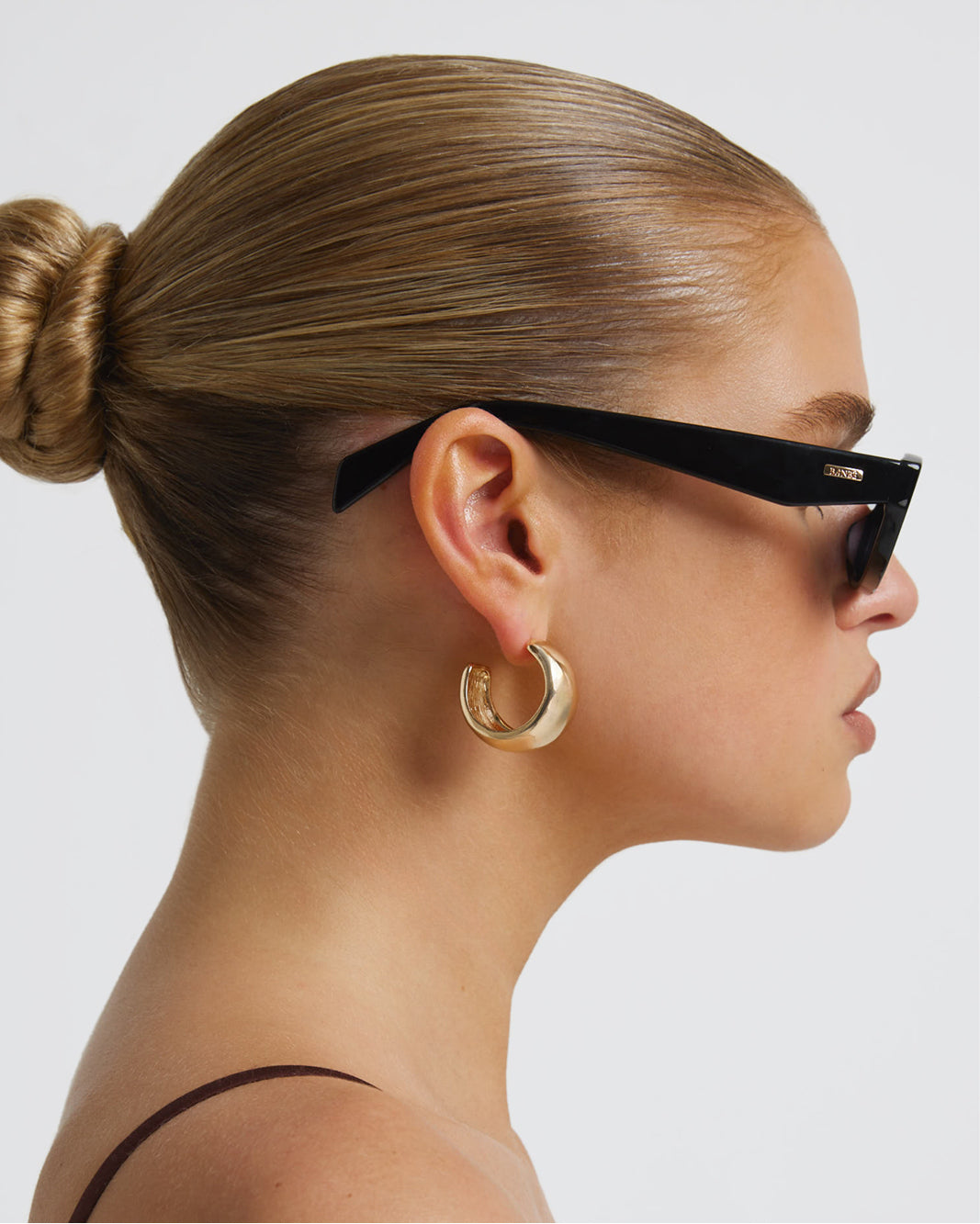 Women's sunglasses with a rectangular silhouette, chunky acetate frame, tonal tinted lenses, and wide arms for a bold, modern look with UV protection side view.