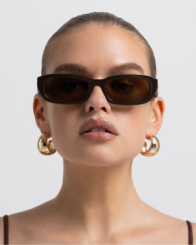 Women’s rectangular sunglasses with tonal tinted lenses, chunky acetate frame, UV Protection, front view on model.
